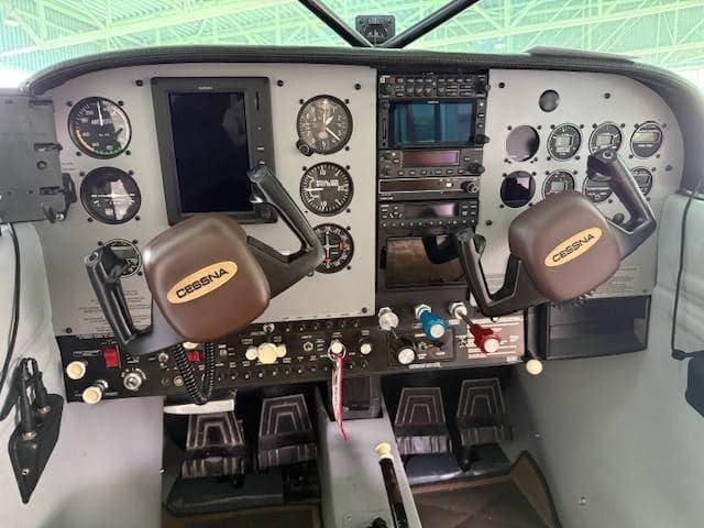 The cockpit instrument panel of a Cessna aircraft, featuring analog gauges and modern avionics.