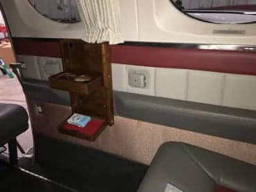 A wooden storage compartment is shown on the interior wall of the aircraft.