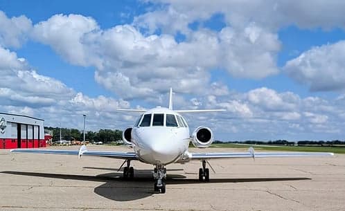 Front view of a Hawker jet with registration N998BM parked on the tarmac.