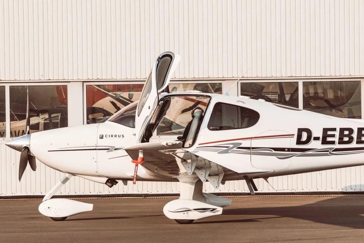 A Cirrus aircraft with registration D-EBBQ with its doors open.