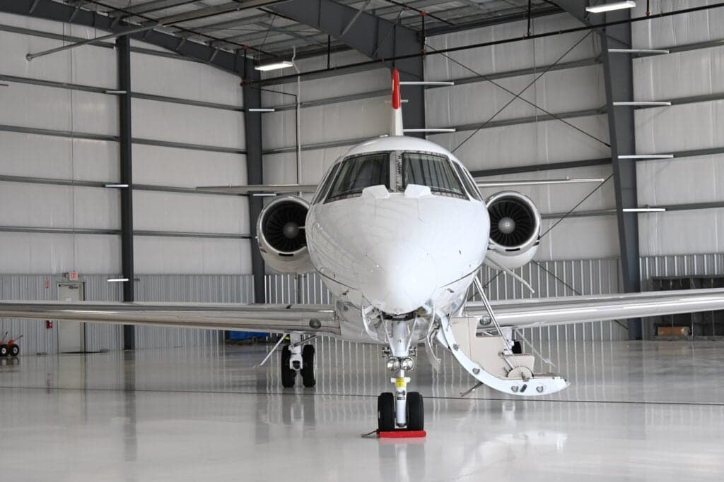 Front view of a Citation Sovereign aircraft with the airstair door open in a hangar.