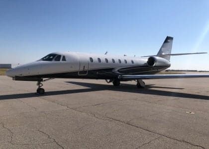 A white and gray Cessna Citation jet sits on the tarmac.