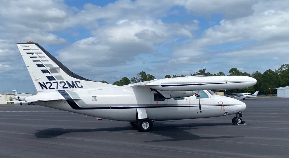 The aircraft N272MC is parked on the tarmac with a white and gray paint scheme.