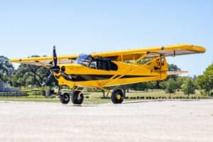 Yellow and black NX Cub aircraft on the ground.