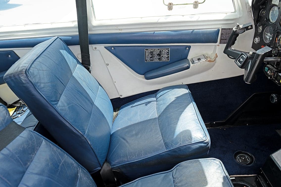 Front blue leather seats of the aircraft interior.