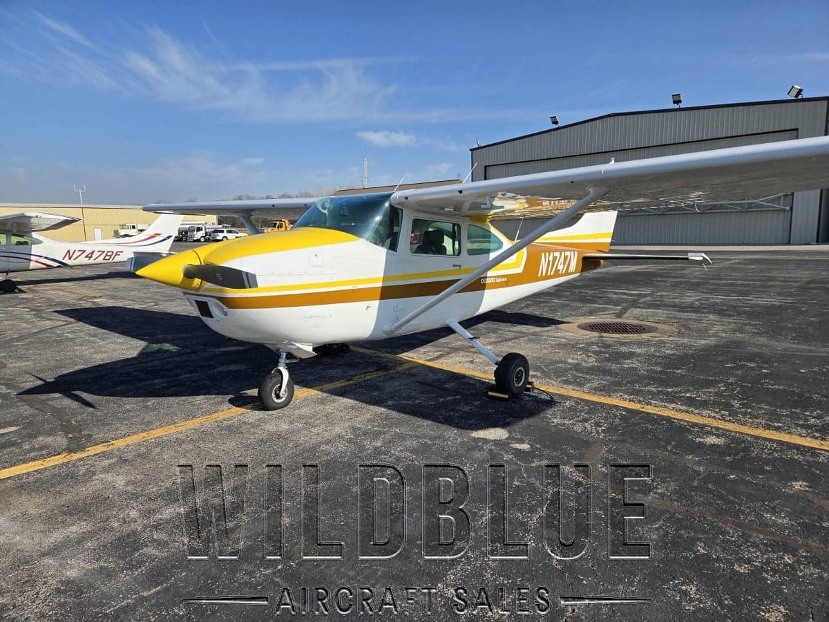 N1747M Cessna Skyhawk with white and gold paint scheme on the tarmac with Wildblue Aircraft Sales watermark.