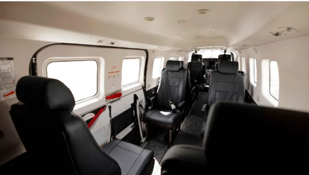 The interior cabin of an aircraft with multiple rows of black leather seats.