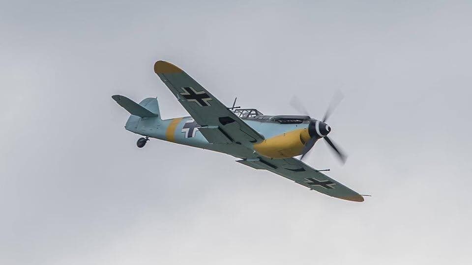 Messerschmitt Bf 109 aircraft in flight against a cloudy sky.