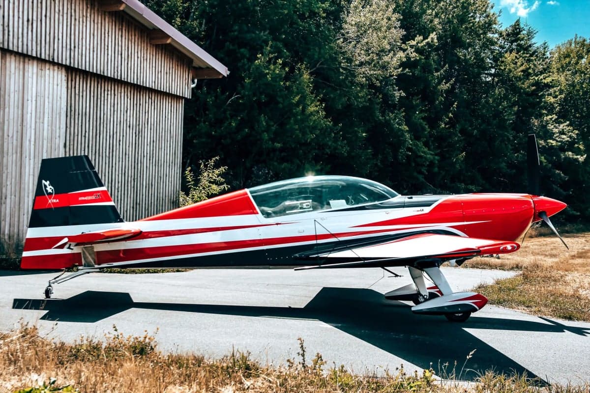 Red and white Extra EA-300LX on the tarmac.