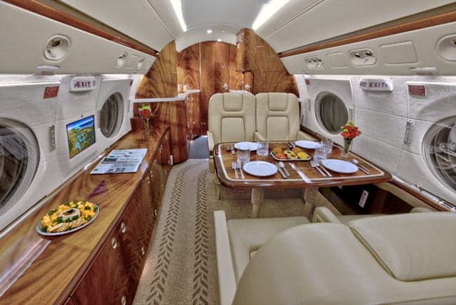 A view of the aircraft's interior, featuring a dining table and comfortable seating.