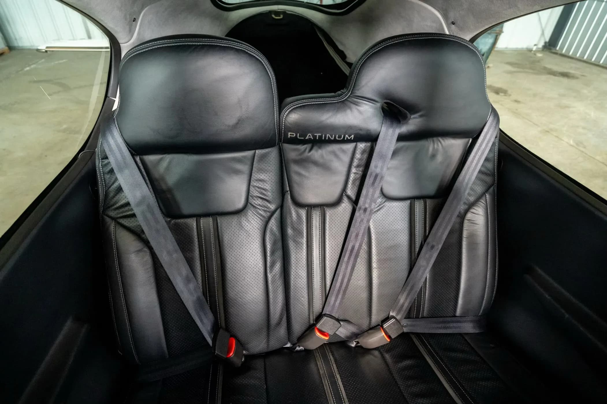 A close-up view of the black leather rear seats of the Cirrus SR22 aircraft cabin.