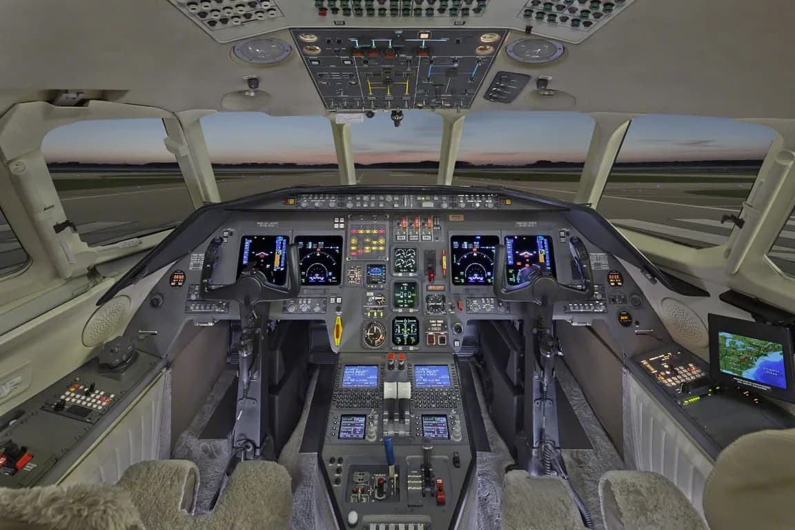 The cockpit of a business jet with multiple digital displays and controls.