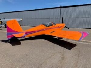 An orange and purple aircraft parked on the tarmac.