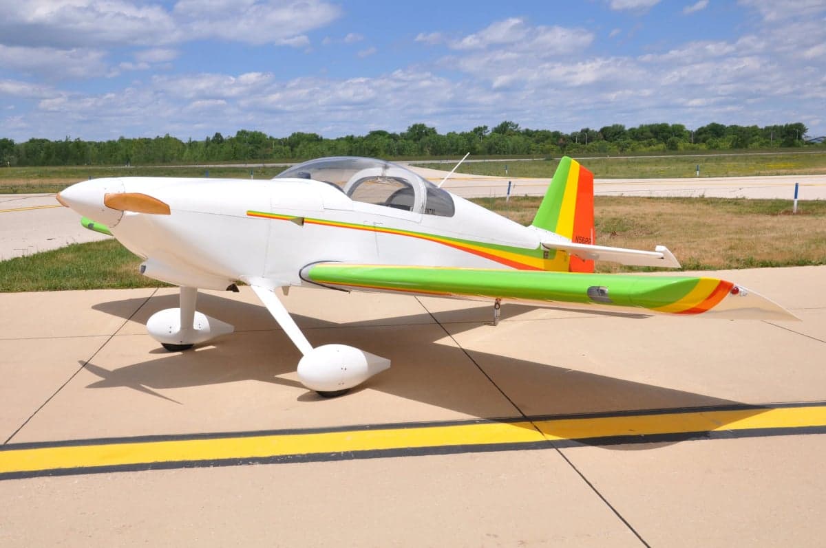 Side view of a white and colorful experimental aircraft on the tarmac.