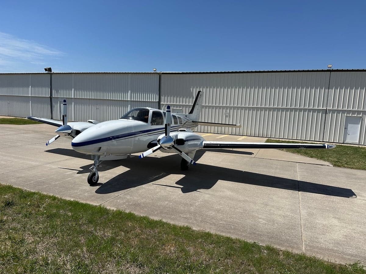 Beechcraft Baron N51FD parked on the tarmac with a white and blue paint scheme.
