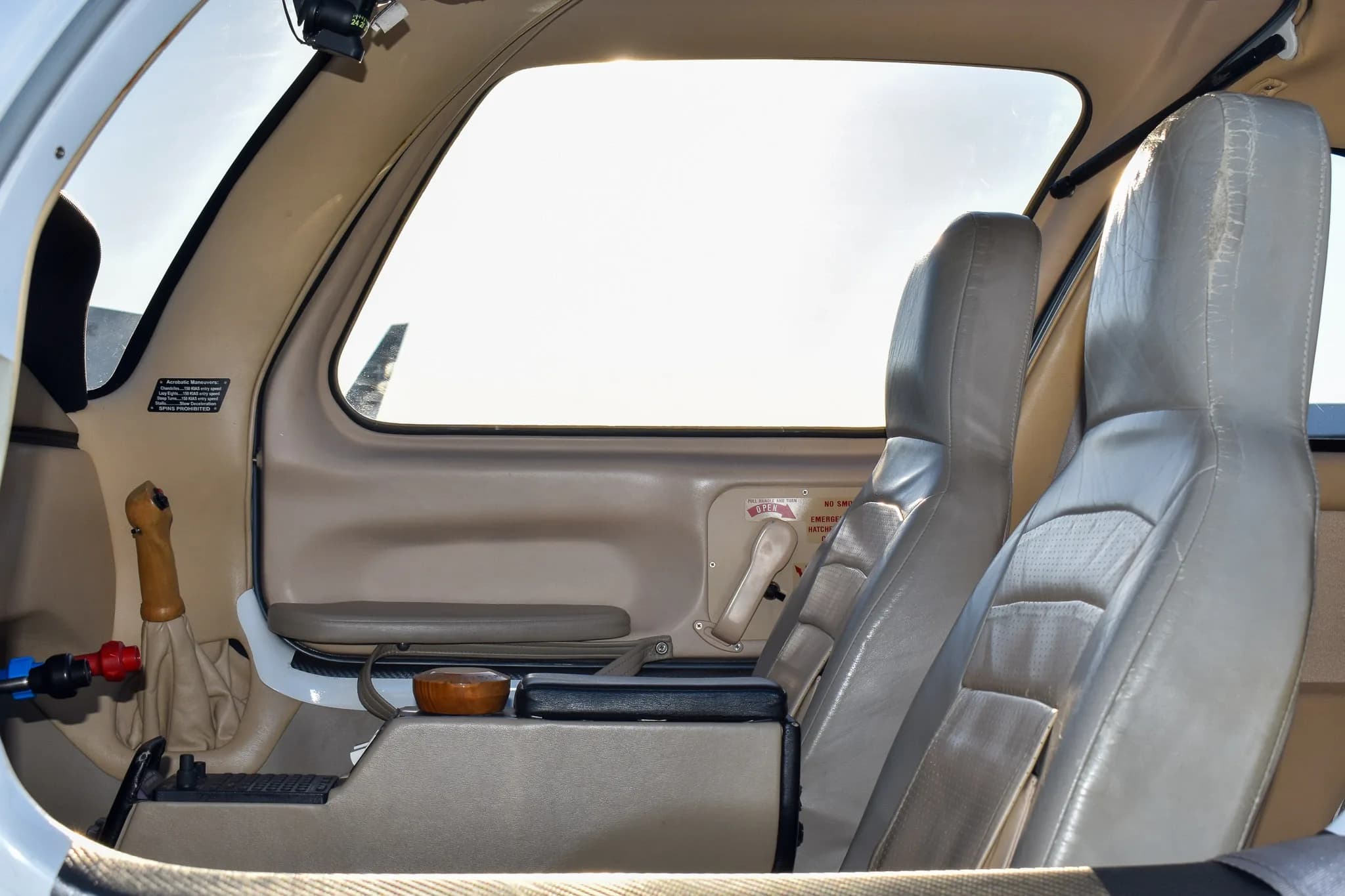 The aircraft's interior cabin showing the side stick control and light-colored seats.