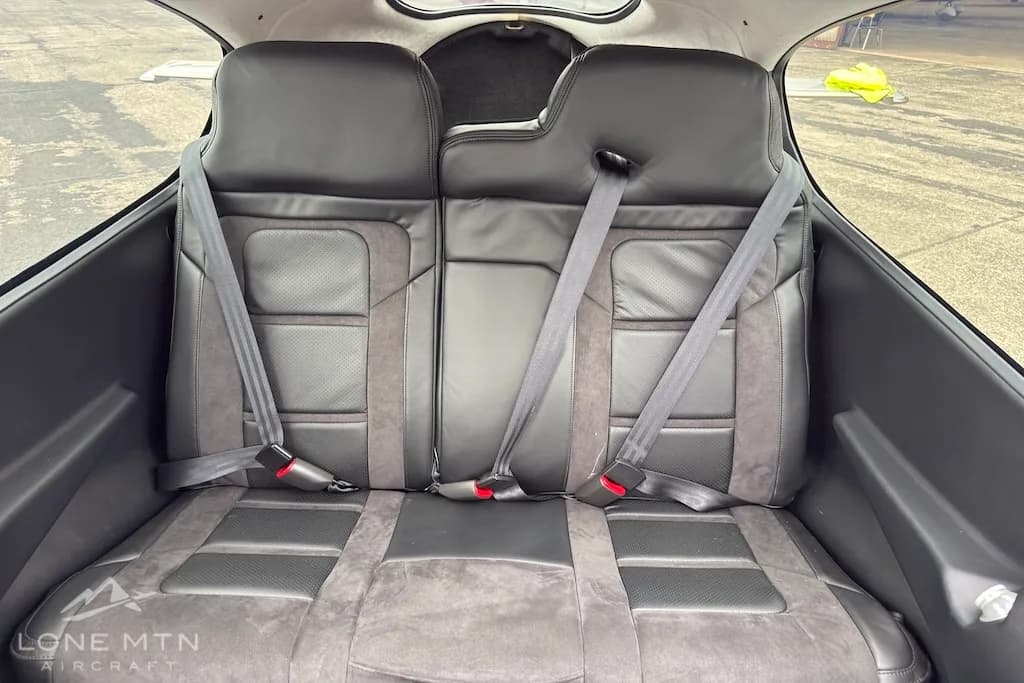 The black and grey rear passenger seats of the Cirrus SR22 aircraft, with seatbelts visible.