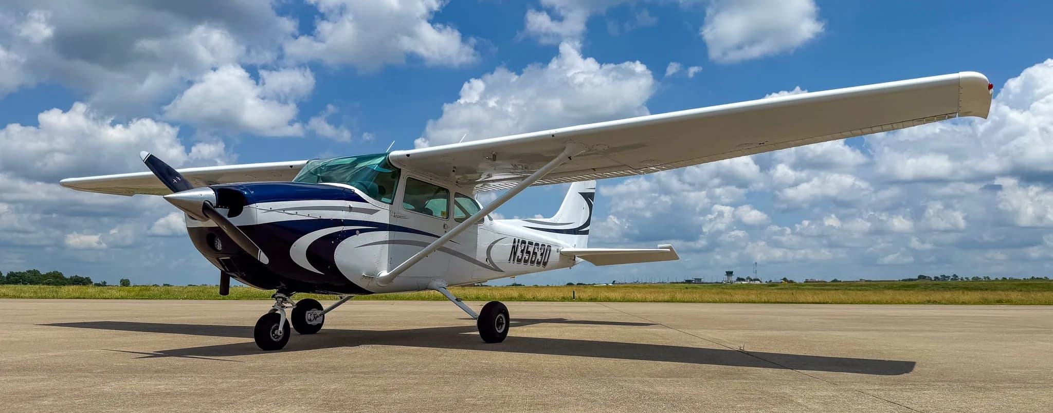 Front-left view of a white and blue Cessna 172 with registration N3563Q parked on an airfield.