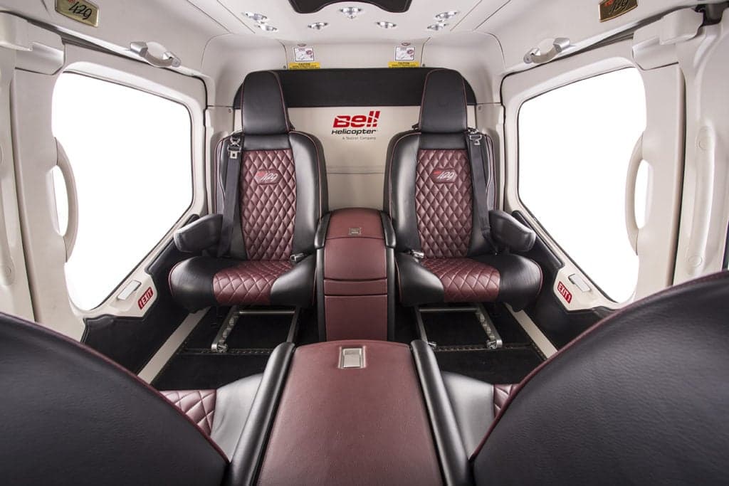 Interior view of a Bell 429 helicopter with burgundy leather seats.