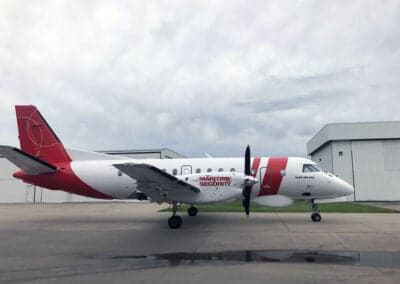 Side view of a Maritime Security Beechcraft 1900 aircraft parked on the tarmac.