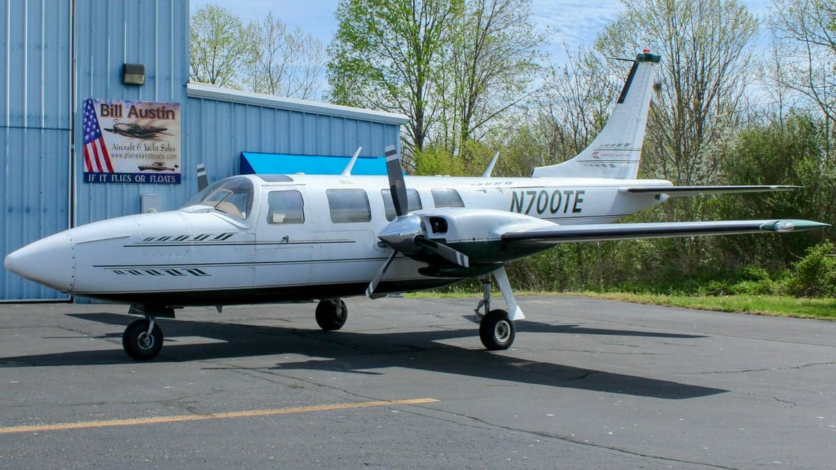Aerostar Super 700 twin parked near a hangar.