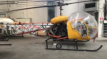 Front view of a helicopter with a bubble canopy, showing the interior.