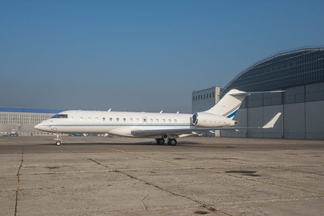 A Bombardier Global Express parked on the tarmac in front of a hangar.