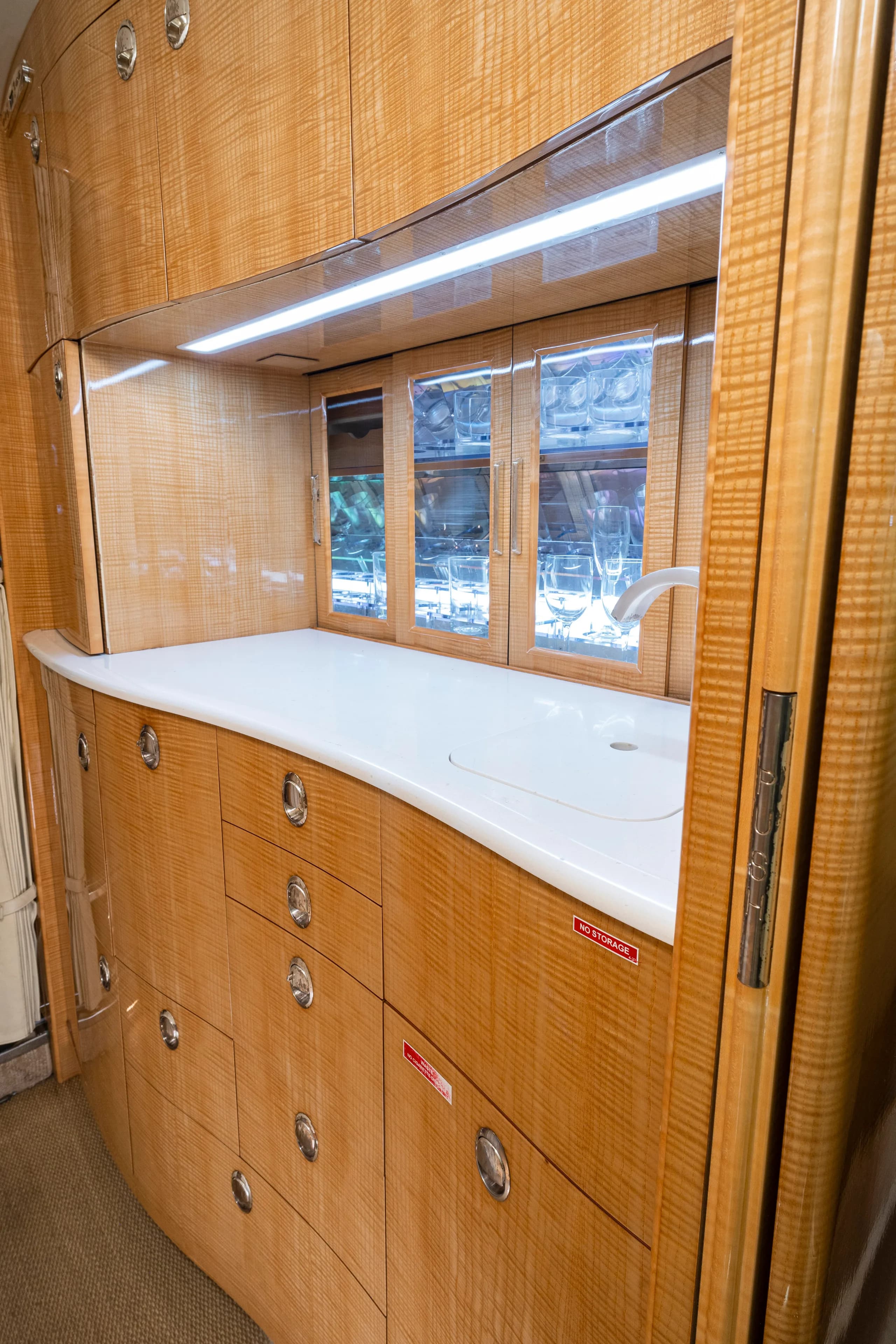 The aircraft's interior features a galley with a sink and storage.