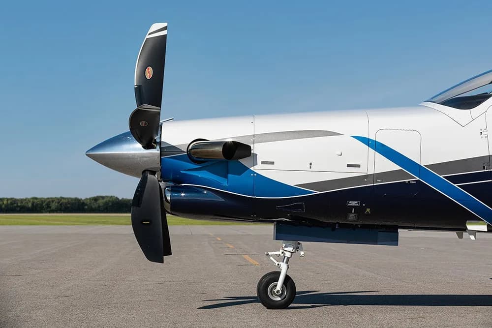 A close-up view of the propeller and front fuselage of the TBM 960 aircraft with blue and white paint.