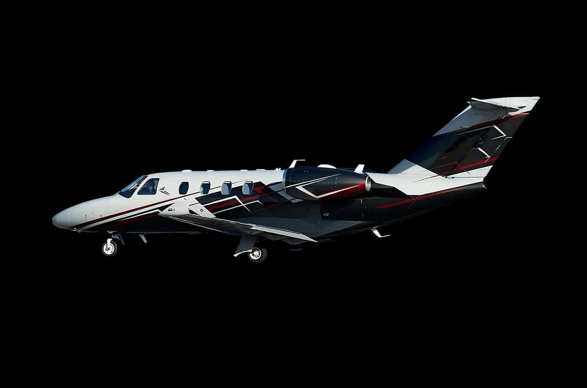 Side view of a black and white Cessna Citation on a black background.