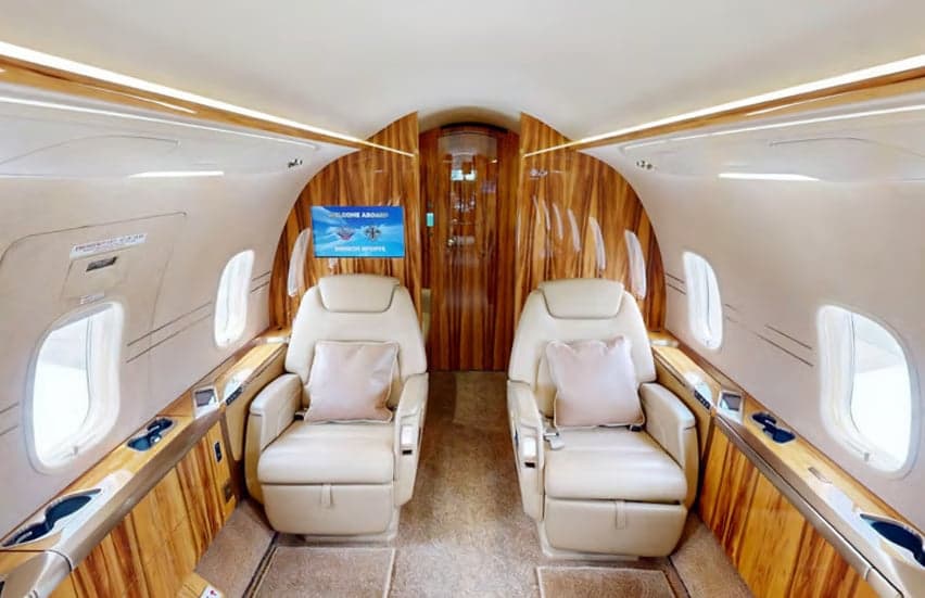 The interior of the Challenger aircraft features wood paneling and leather seats.