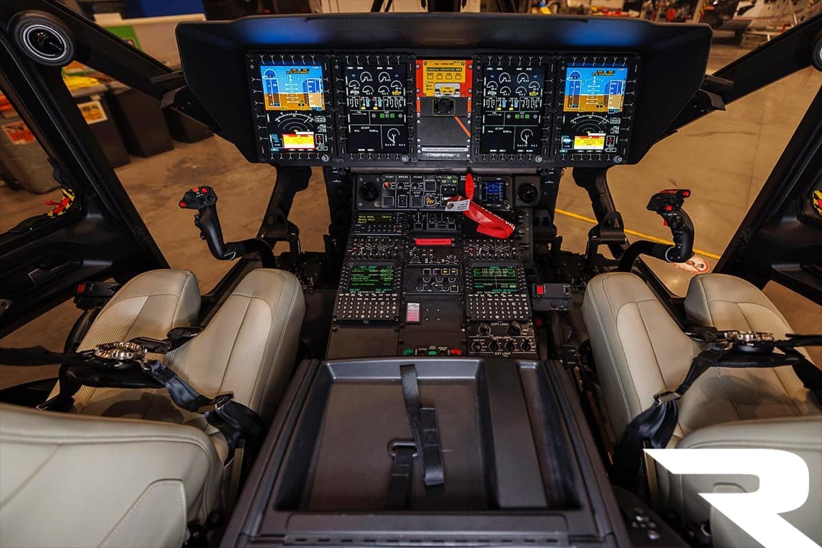 The modern glass cockpit of an Airbus H160 helicopter with multiple digital displays and controls.