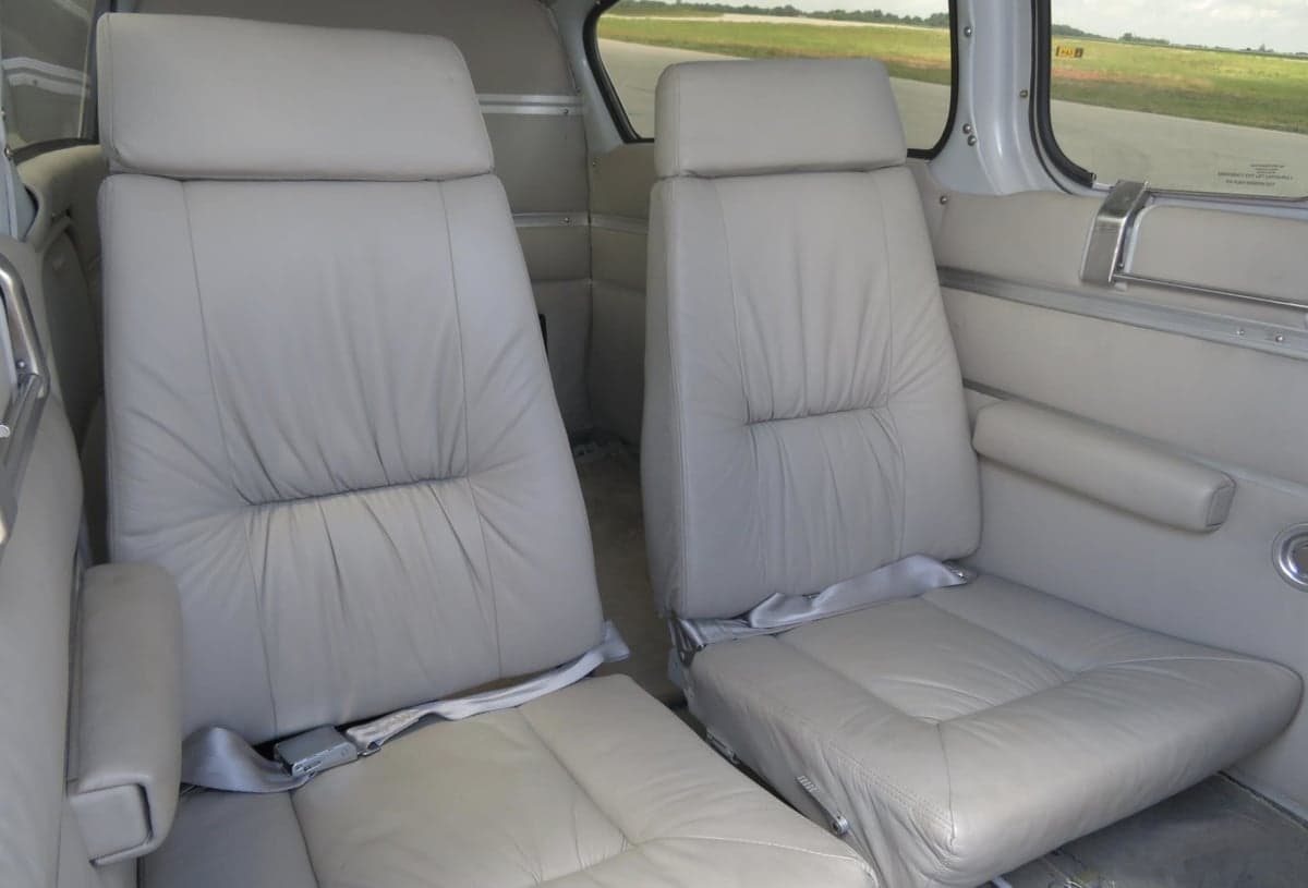 Close-up of the light gray leather seats in the aircraft cabin.