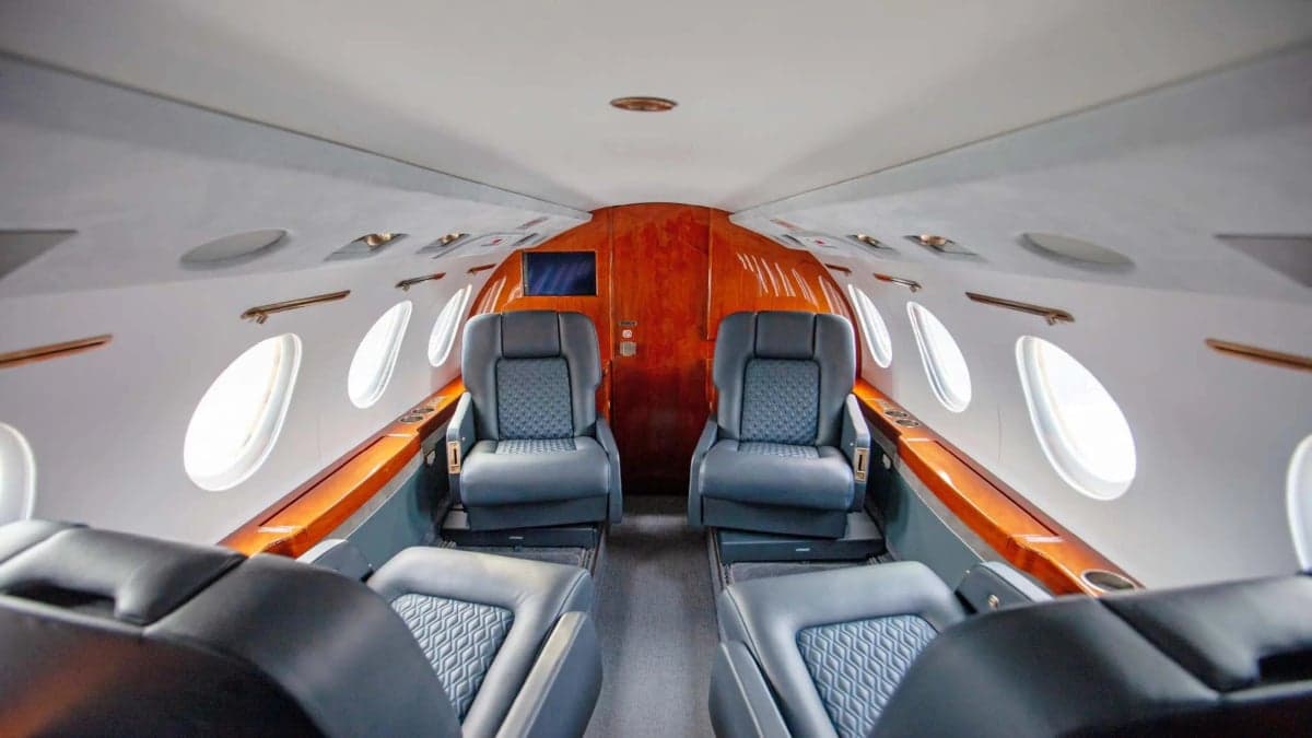 The interior of a Falcon jet with leather seats.