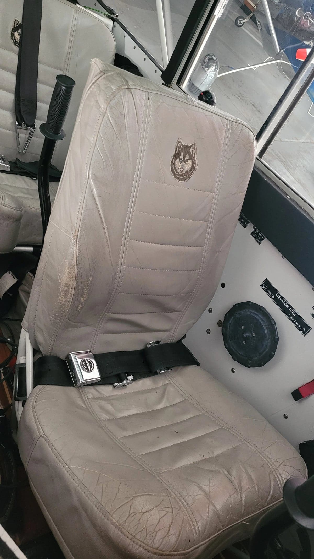 Close-up of the pilot's seat inside the Aviat Aircraft Husky A-1B aircraft, featuring a Husky logo.