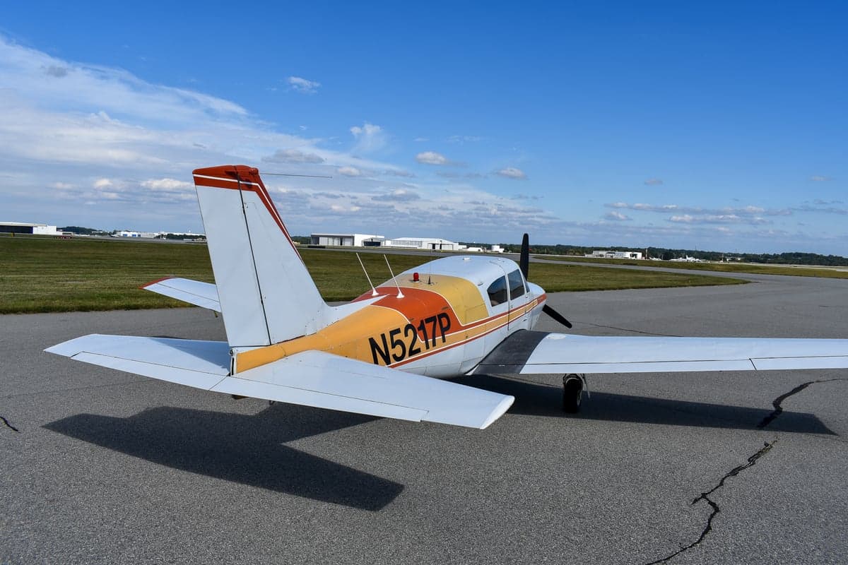 Piper Comanche 250 aircraft, side view, on the tarmac with registration N5217P.