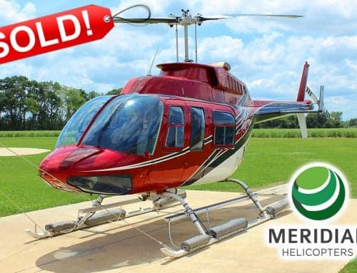 A red and white Bell 206 helicopter is shown on a concrete pad with a SOLD banner.
