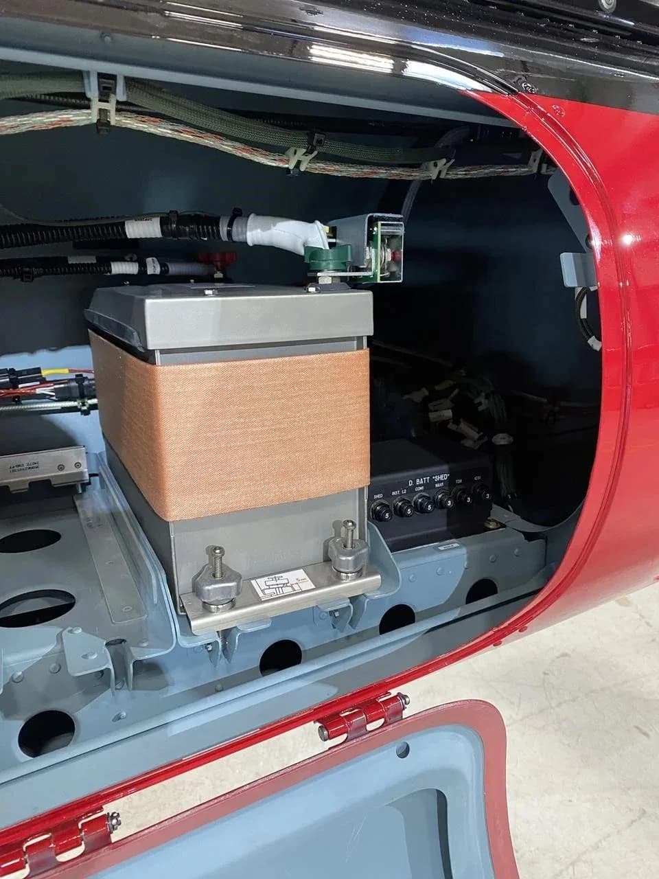 A close-up view of an open compartment revealing internal components and wiring of the helicopter.