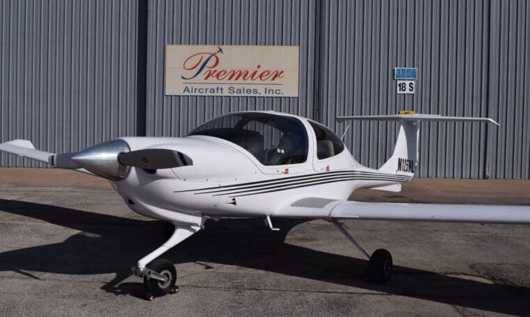 Front view of a Diamond DA40 aircraft with registration N125HL parked in front of a hangar.