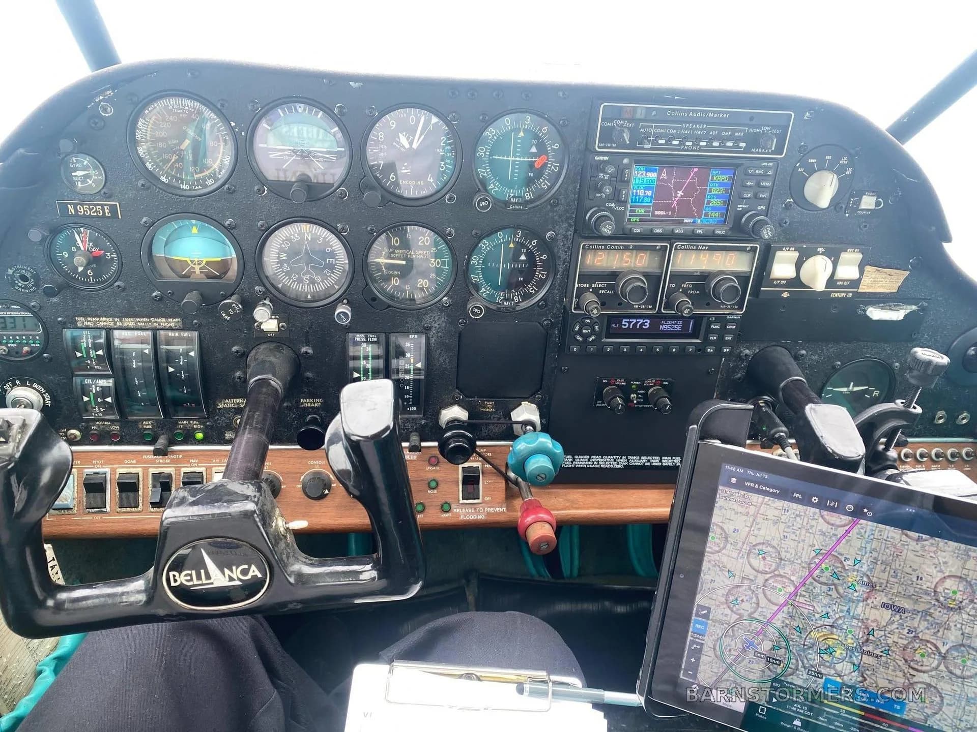 A view of the Bellanca aircraft cockpit with a black instrument panel, dual yokes, and a tablet displaying a map.