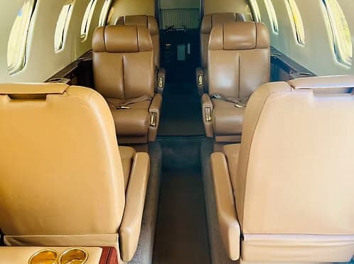 Interior view of the aircraft cabin with tan leather seats.