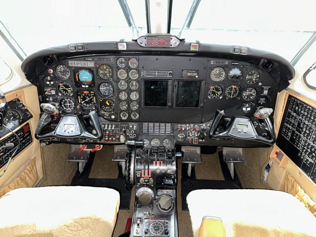 The cockpit of the aircraft, featuring a classic analog instrument panel with dual yokes and a central throttle quadrant.