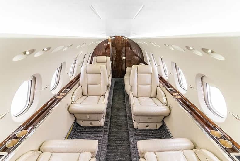 View of the aircraft's interior with leather seats and wood trim.