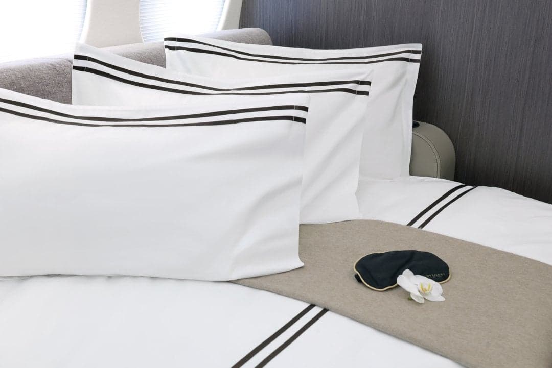 Interior of the aircraft featuring a bed with white linens and a black striped pattern.