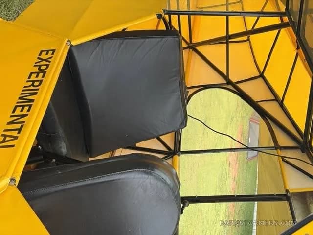 The black seats and yellow fabric interior of an experimental aircraft, showing the "EXPERIMENTAL" label.