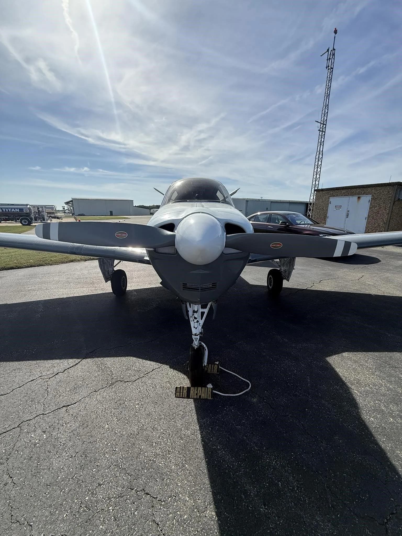 Front view of the N2194D Beechcraft Bonanza V-tail aircraft, showing its propeller and nose gear on the tarmac.