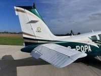 The tail section of a Beechcraft Bonanza with a white paint scheme.