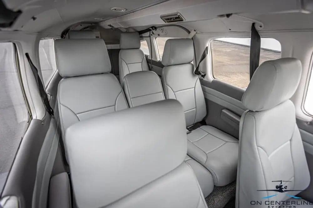 View of the cabin of a Piper PA-32R-301 Saratoga SP, featuring gray leather seats.