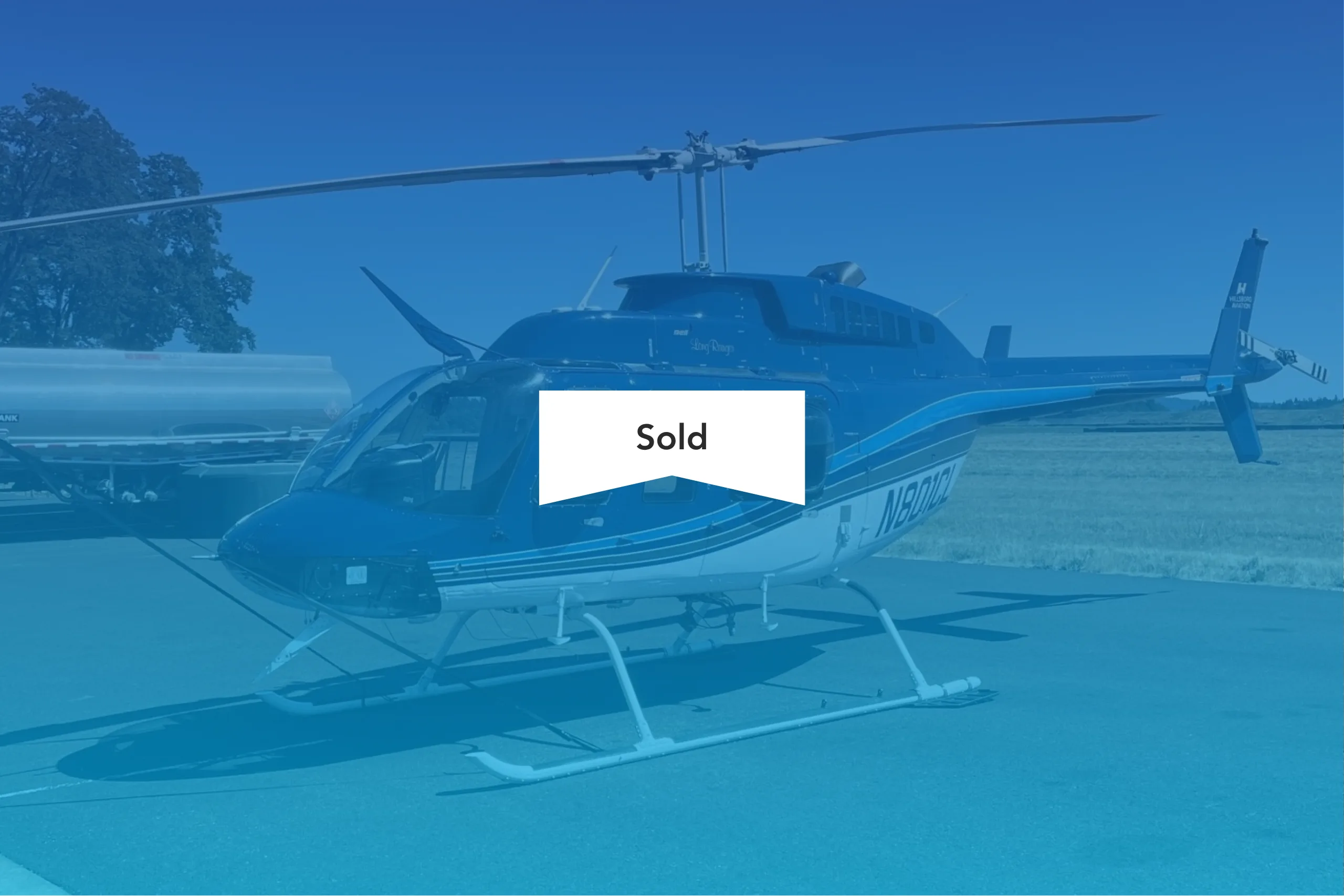 Bell 206B Jet Ranger with blue and white paint scheme, with a SOLD banner overlaid.