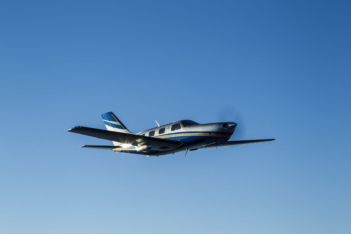 Piper M350 flying in a clear blue sky.